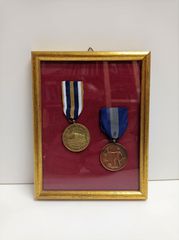 Δύο αναμνηστικά μετάλλια σε κορνίζα που αφορούν την Εθνική Αντίσταση.