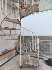 Περιστροφική σιδερένια σκάλα εξωτερικού χώρου και δέκα μέτρα κάγκελα.