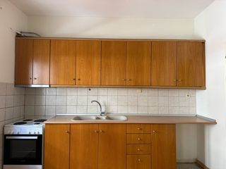 Κουζίνα με πάνω κάτω ντουλάπια πάγκο και νεροχύτη