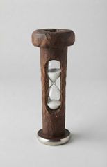 An hourglass within a wooden thread spool.